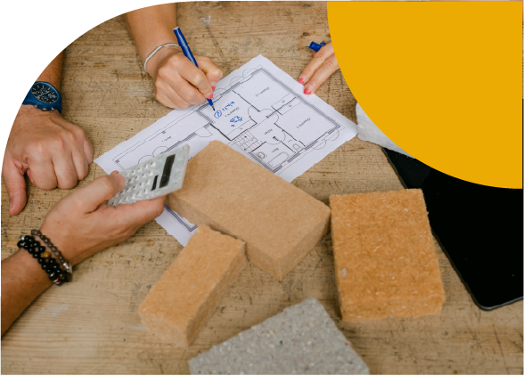 mains touchant des plans de maison avec des materiaux isolants